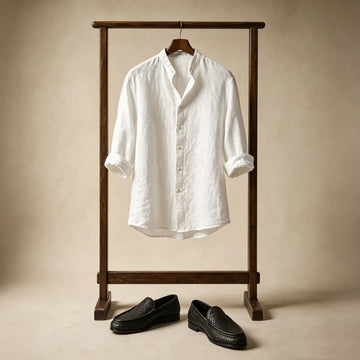 White linen shirt hanging on wooden rack with woven leather loafers