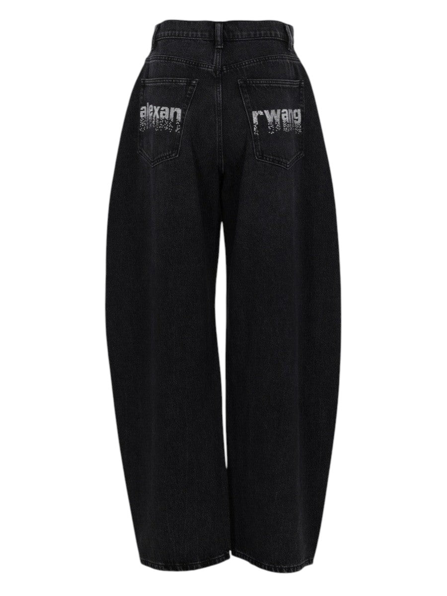 Back view of Alexander Wang black denim jeans with rhinestone logo embellishment on the rear pockets and wide-leg fit.