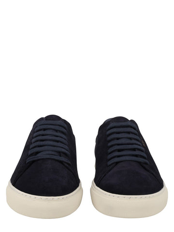 Axel Arigato navy suede low-top sneakers featuring tonal laces, gold logo detail, and an off-white rubber sole.