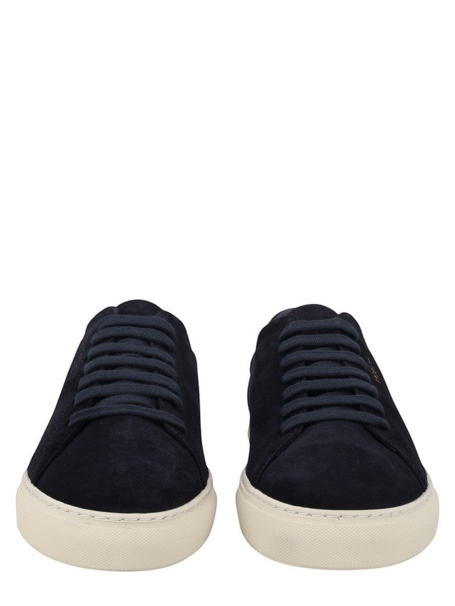 Axel Arigato navy suede low-top sneakers featuring tonal laces, gold logo detail, and an off-white rubber sole.