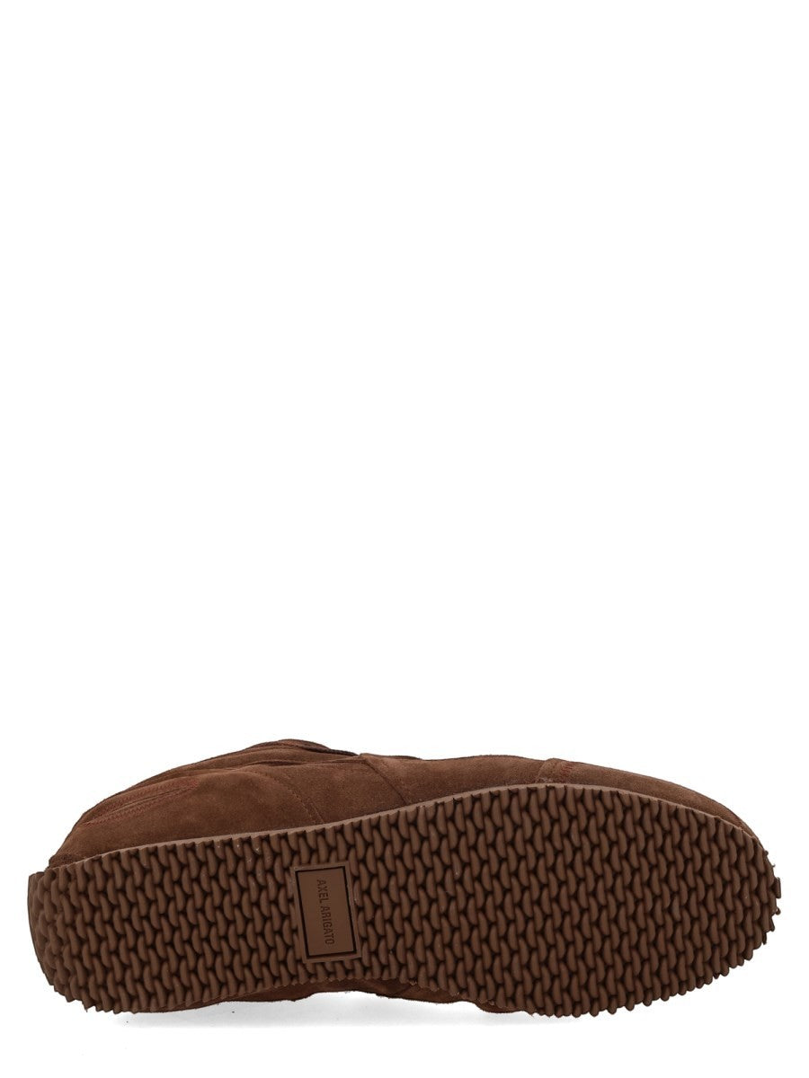 Textured rubber outsole of the AXEL ARIGATO Slow Runner sneaker in brown with raised grip pattern and logo detail.