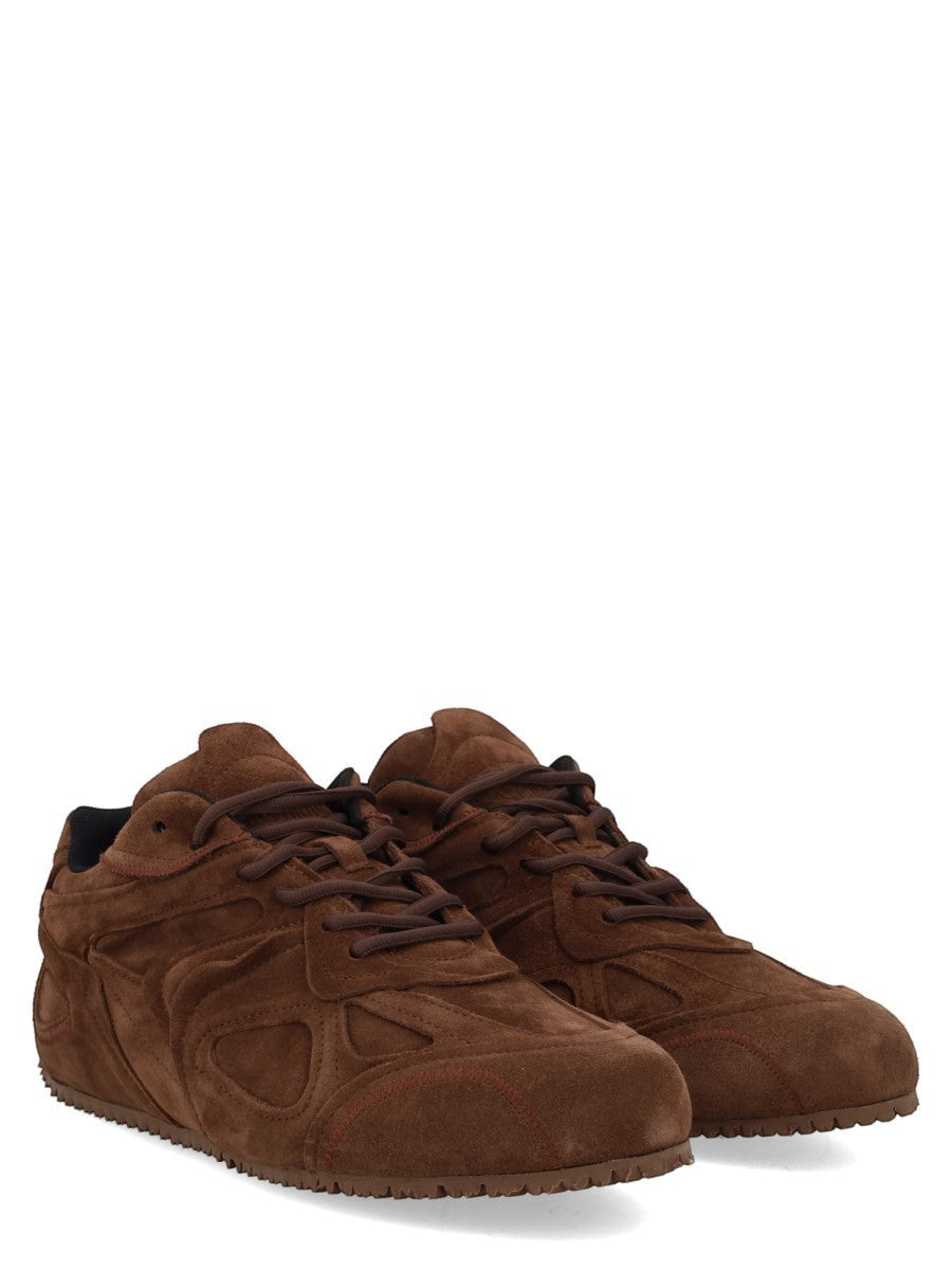 Three-quarter view of the AXEL ARIGATO Slow Runner sneaker in brown suede with sculpted panels and tonal rubber sole.