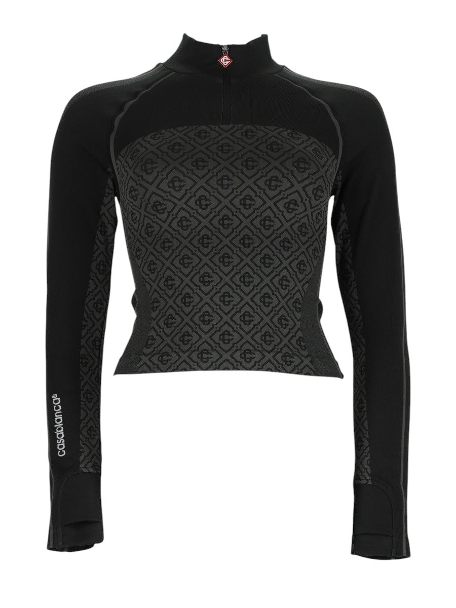 Front view of CASABLANCA black fitted top with zip collar, long sleeves and monogram jacquard panel